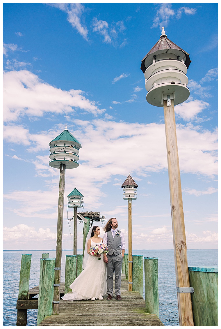 The bride and groom enjoy the waterfront with gorgeous blue skies for their wedding day at Black Walnut Point Inn | Laura's Focus Photography
