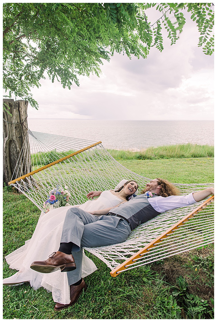 The bride and groom take a moment to relax in the hammock on the lawn at Black Walnut Point Inn | Laura's Focus Photography