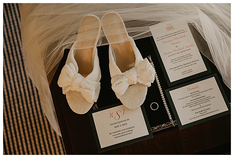 A detail portrait of the bride's wedding shoes along with the invitation suite and jewelry