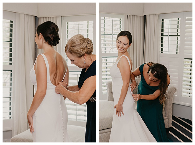The bride dresses in her wedding gown with the help of her mother and maid of honor