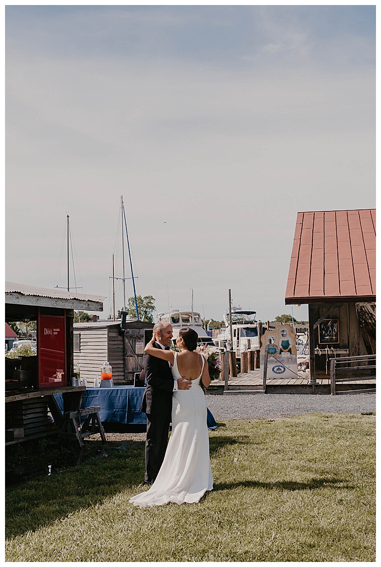 The bride and groom walk to their reception, and stop to have a private moment together as newlyweds by the docks at the Chesapeake Bay Maritime Museum