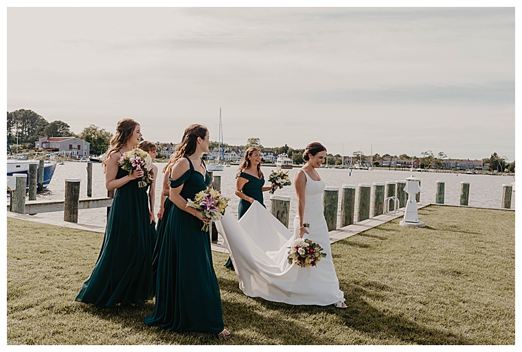 The bridesmaids escort the bride to the waterfront for some time with her groom by carrying the beautiful pearl buttoned train on her dress