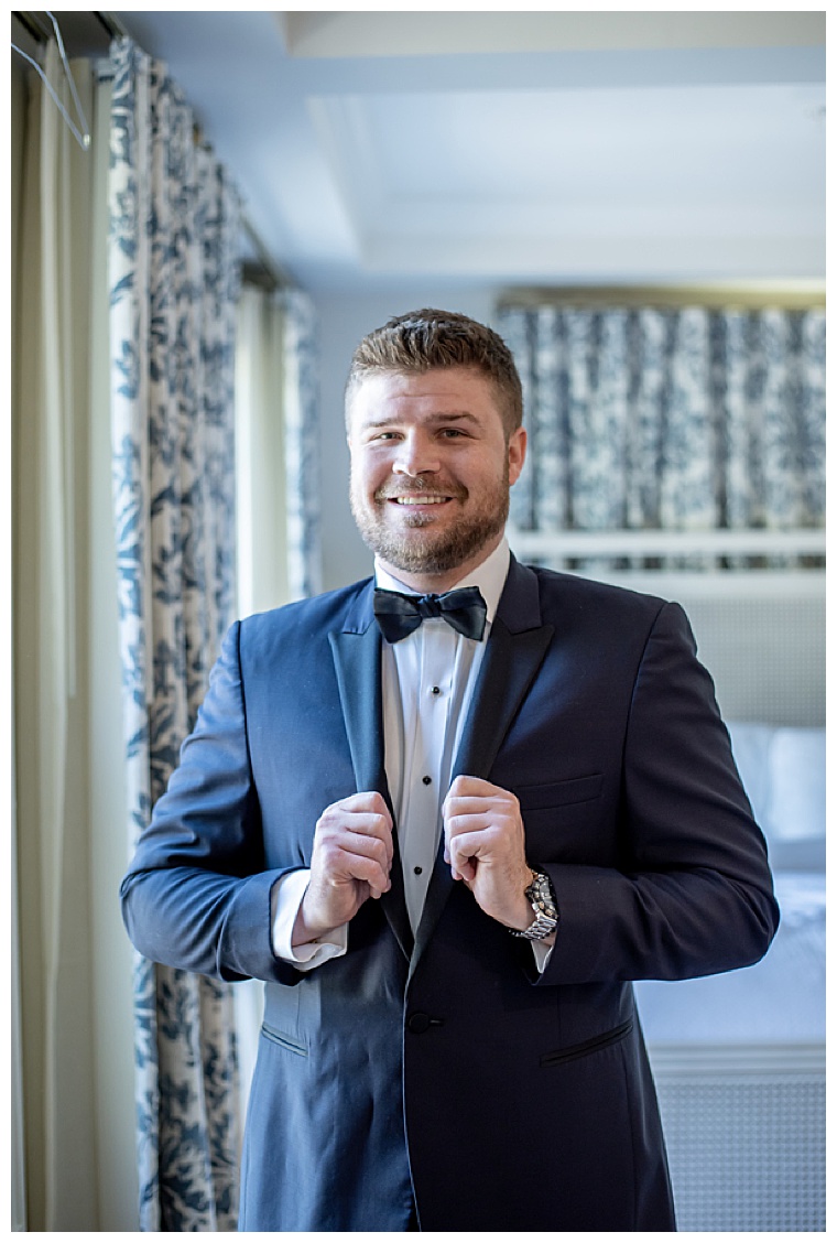 The groom suits up for his eastern shore wedding day in a classic black suit and bowtie