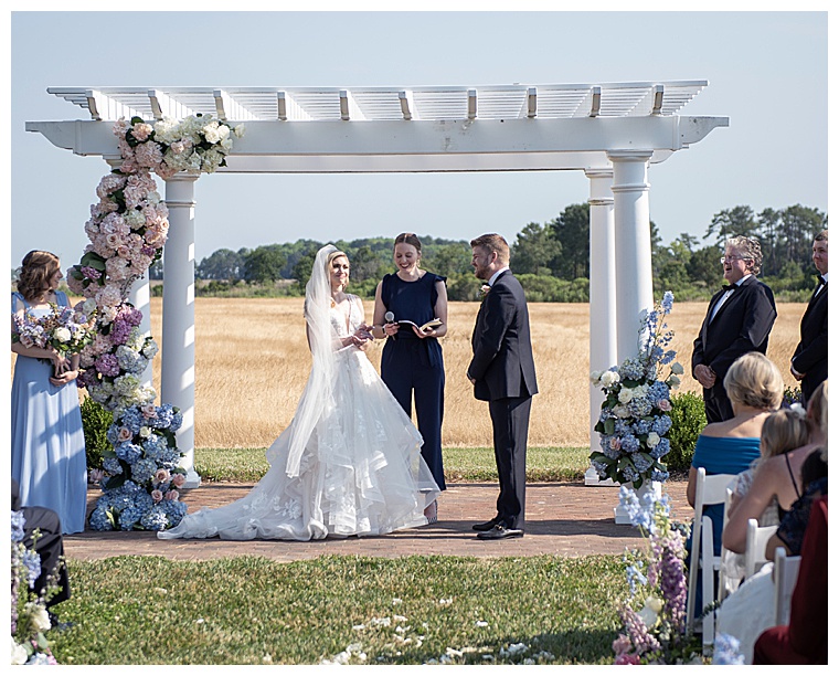 The bride and groom exchange their wedding vows under an arch decorated in stunning hydrangeas on the Eastern Shore of Maryland