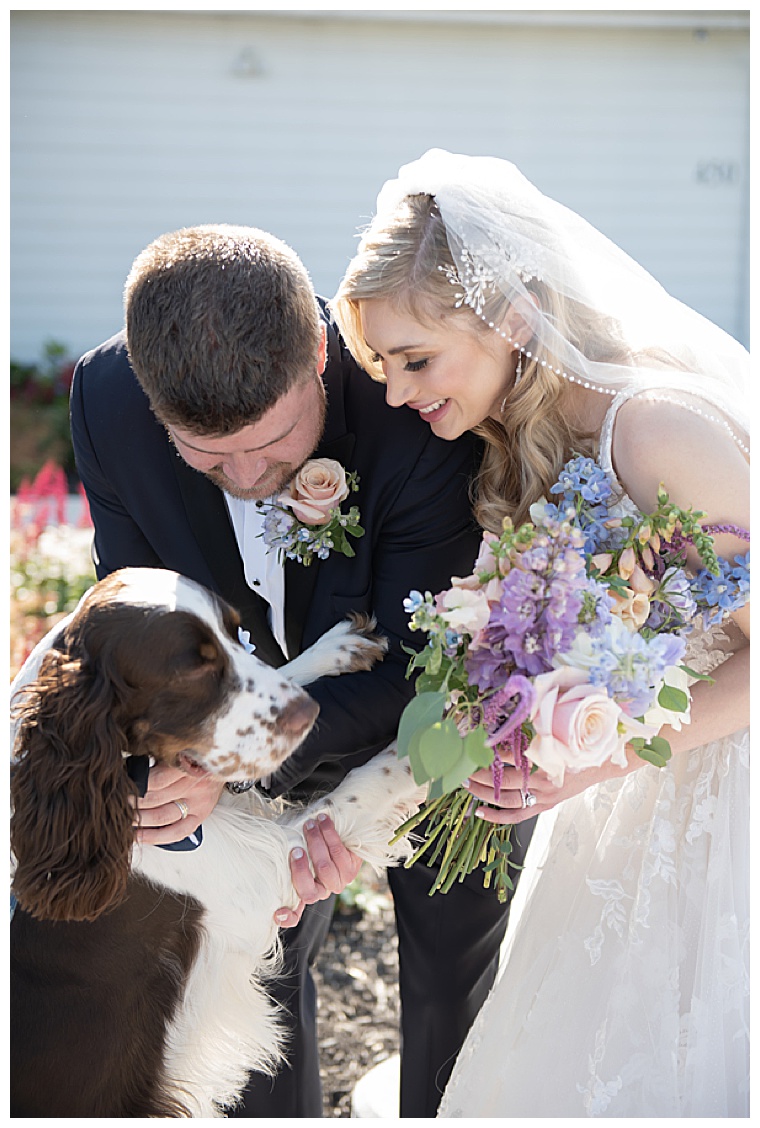 The bride and groom are greeted with love from their furry friend after they exchange their vows during their eastern shore wedding ceremony
