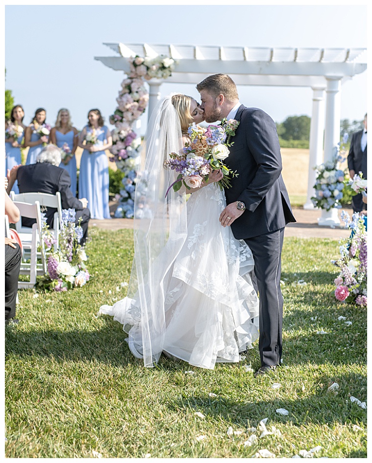 The bride and groom share a romantic kiss as they process down the aisle after exchanging their vows | My Eastern Shore Wedding