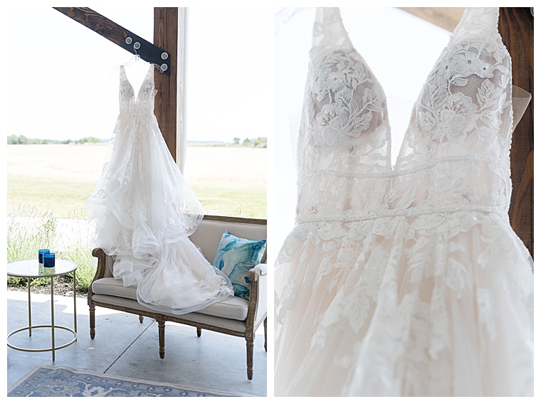 A lace gown with a sheer bodice and tiered a-line skirt hangs awaiting the bride
