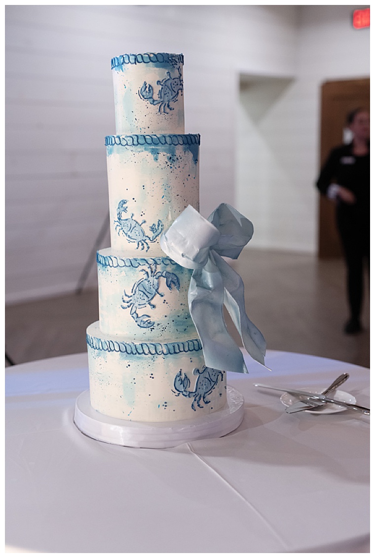 A 4 tiered wedding cake is decorated in white icing with blue nautical details of dock lines and MD Blue Crabs for this Eastern Shore Wedding Reception