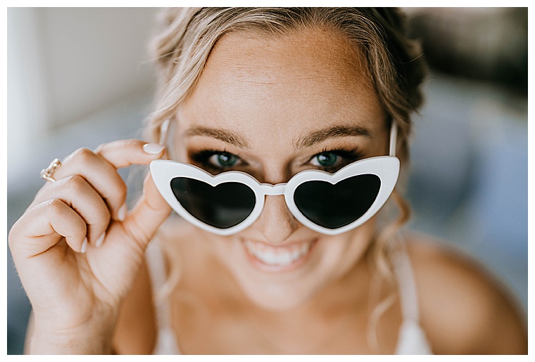 This bride is all smiles for her wedding day as she shows off her wedding day sunnies, white hearts all the way for this lover