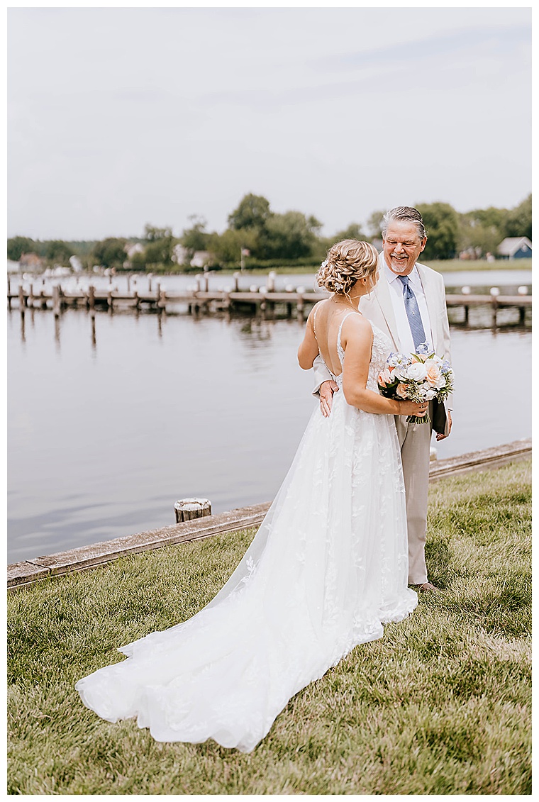 The bride meets her father at the waterfront for a Father Daughter First Look at the Inn at Haven Harbour