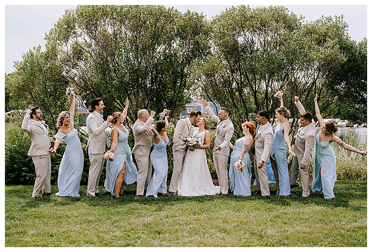 The bridal party cheers on as the soon to be husband and wife embrace in a kiss on the lawn at the Inn at Haven Harbour