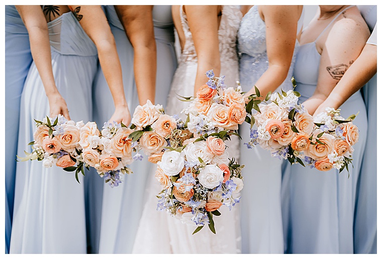 The bridesmaids show off their baby blue dresses and their stunning peach rose bouquets