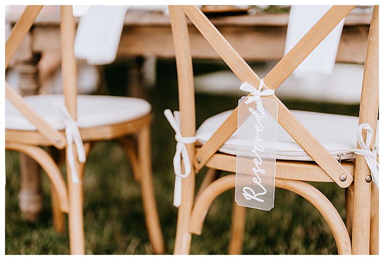 The bride and groom's chairs are marked with acrylic "Reserved" signs at the sweetheart table from Eastern Shore Tents and Events | Haven Harbour Marina Resorts | Inn at Haven Harbour