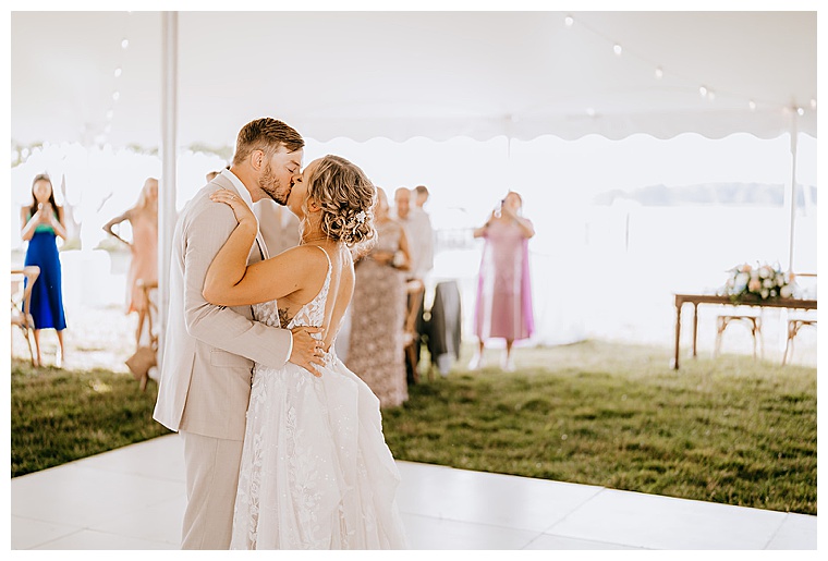 The newlyweds share a first dance on the lawn at the Inn at Haven Harbour under an Eastern Shore Tents and Events tents with a beautiful white dance floor and farm house tables