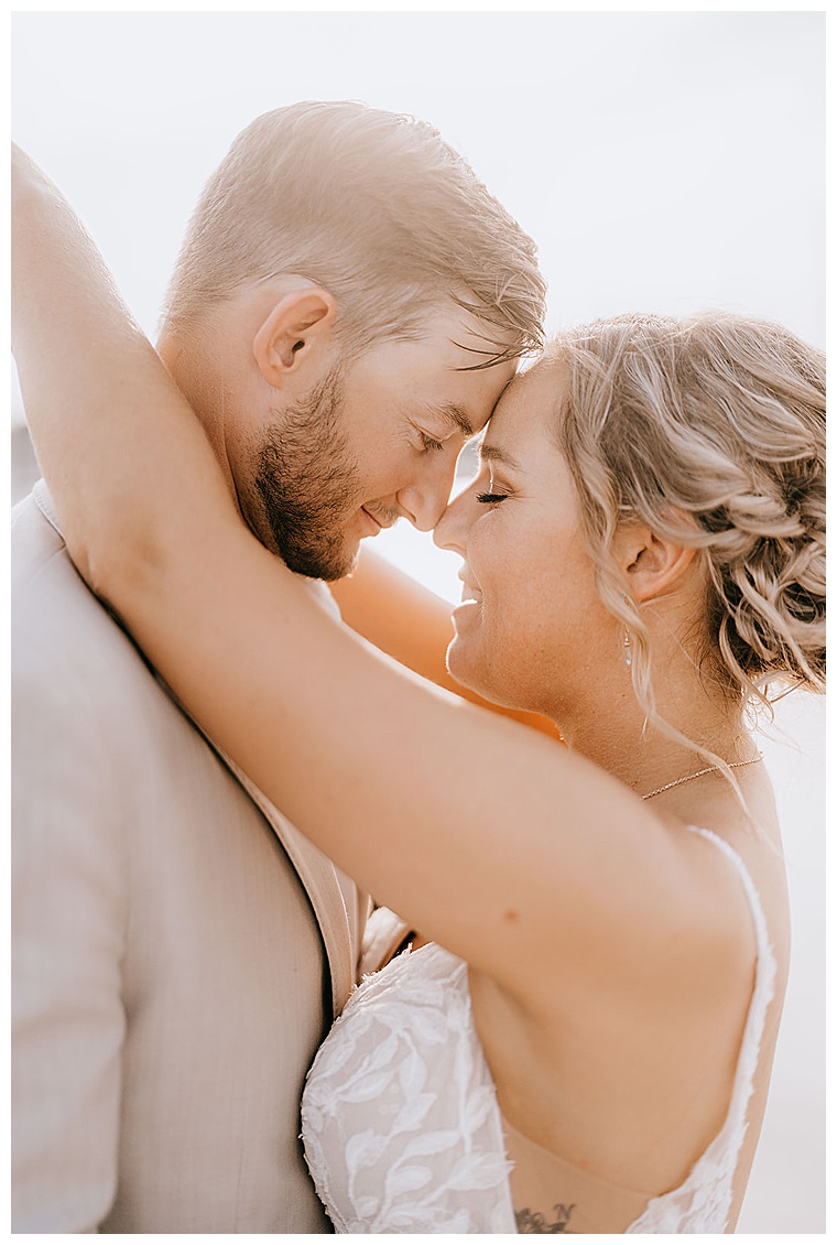 A golden hour bridal portrait of the new husband and wife as they embrace in a romantic hug after exchanging their wedding vows
