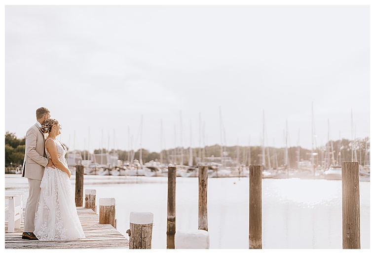The bride, dressed in a stunning lace gown, enjoys the view of the Haven Harbour Marina with her new husband