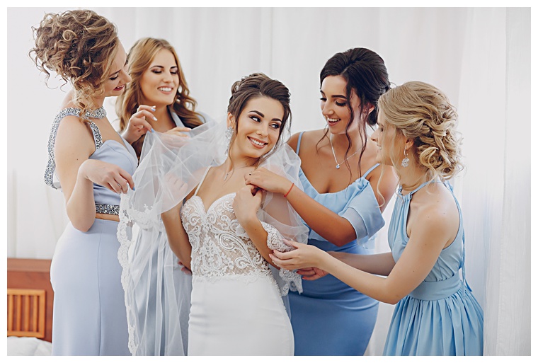 Shining in blues, these bridesmaids have various shades and styles of dress to compliment the brides lace gown.