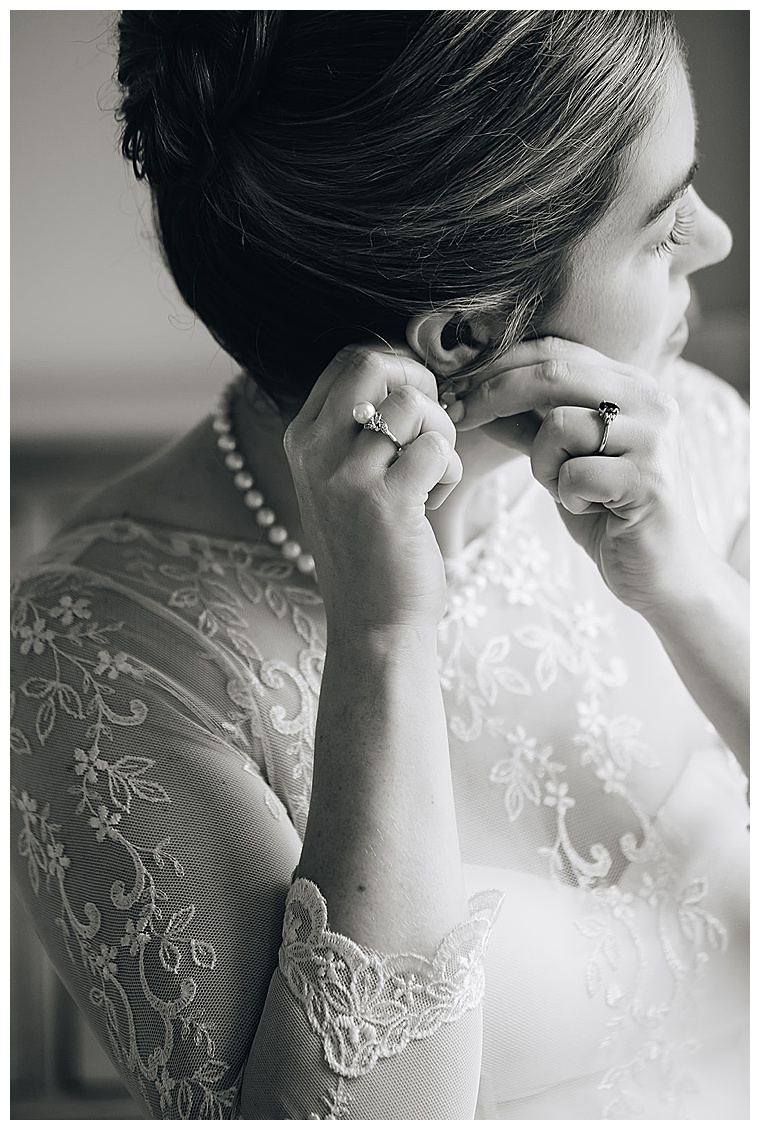 The bride wears a stunning pearl necklace to perfectly compliment the lace details of her dress