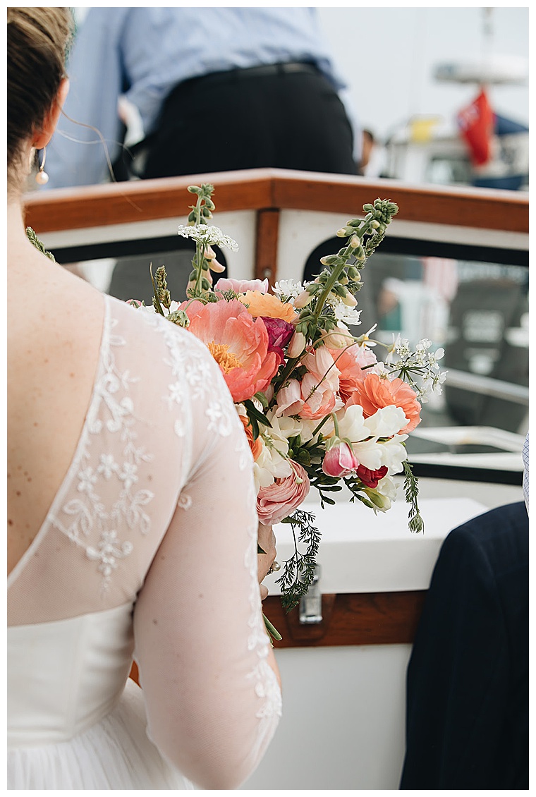 The bride boards her ceremony sailboat to meet her groom at beautiful altar on the bow