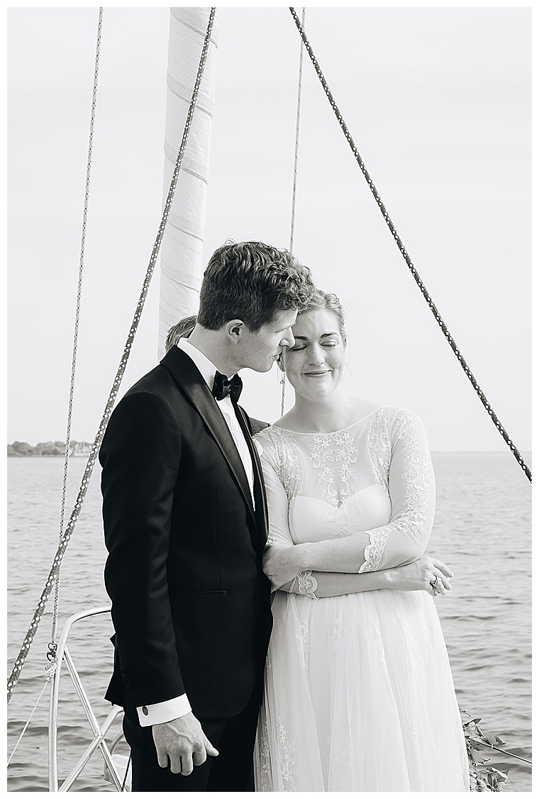 The bride and groom embrace their romantic waterfront ceremony with smiles and romance galore