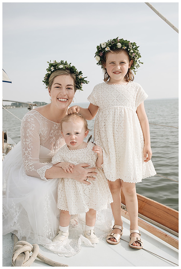 A portrait of the bride and flower girls, all dressed in white lace gowns for a beautiful Eastern Shore Wedding