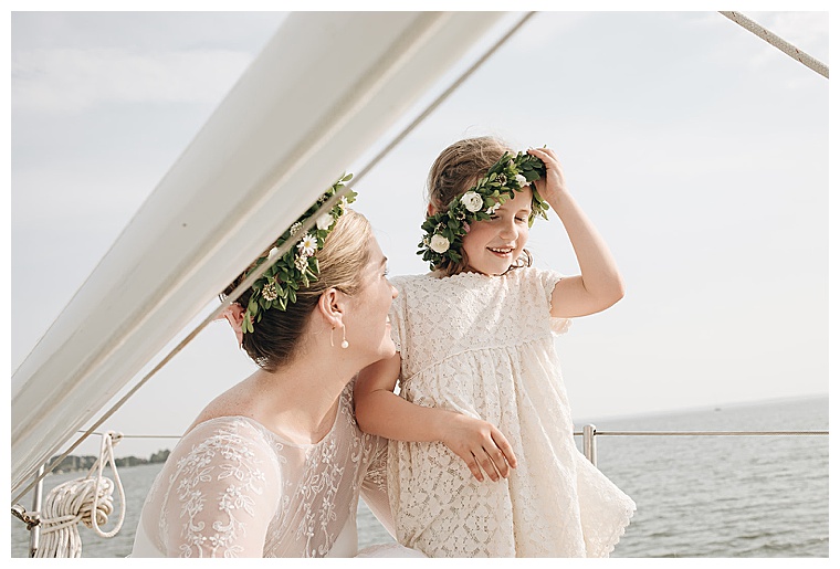 Sporting a beautiful flower crown, the bride shares a laugh with her adorable flower girl on the shores of the tred avon river in oxford maryland | My Eastern Shore Wedding
