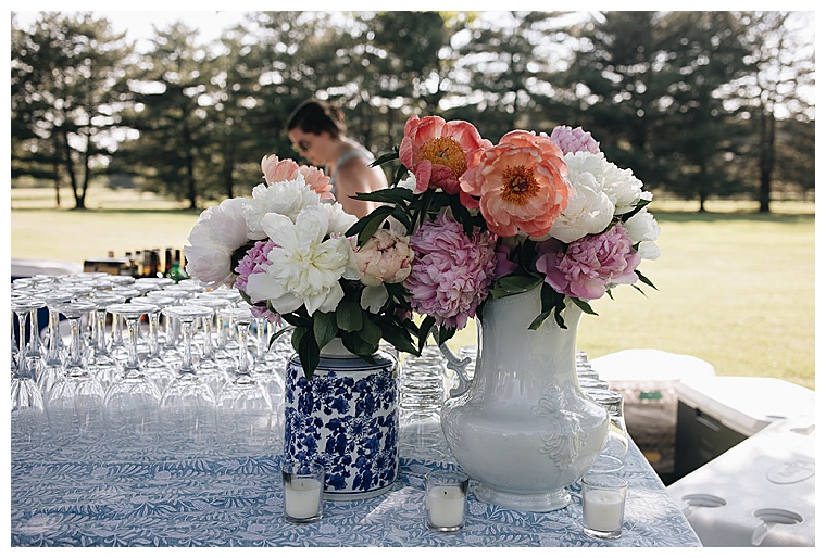Welcome drinks are staged with pastel purple and peach florals in vintage vases