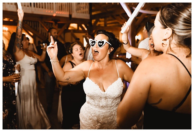The bride hits the dance floor with her new husband sporting white heart sunglasses and a stunning lace gown