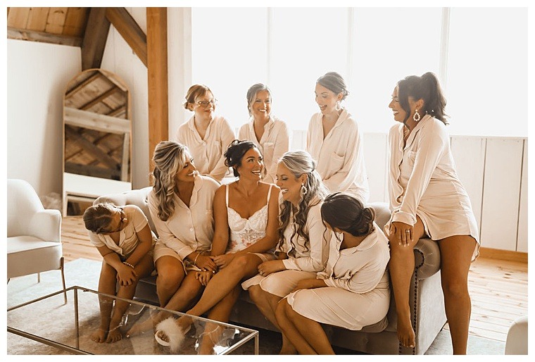 Bridesmaids sporting neutral colored pajamas as they get ready for the ceremony