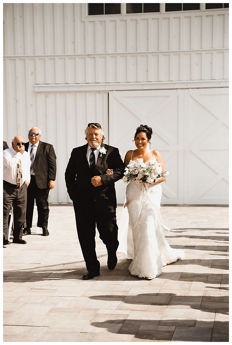 The bride is walked down the aisle by her father to meet her soon to be husband outside Breckenridge Barn