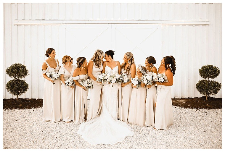 Bridesmaids surrounded the bride with love and support for her Breckenridge Barn wedding day with bouquets by Sherwood Florist