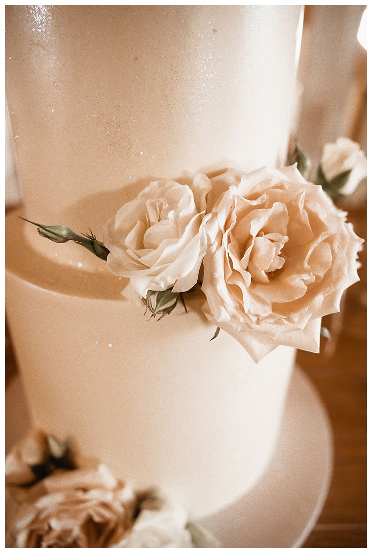 Florals by Sherwood Florist top this stunning white wedding cake