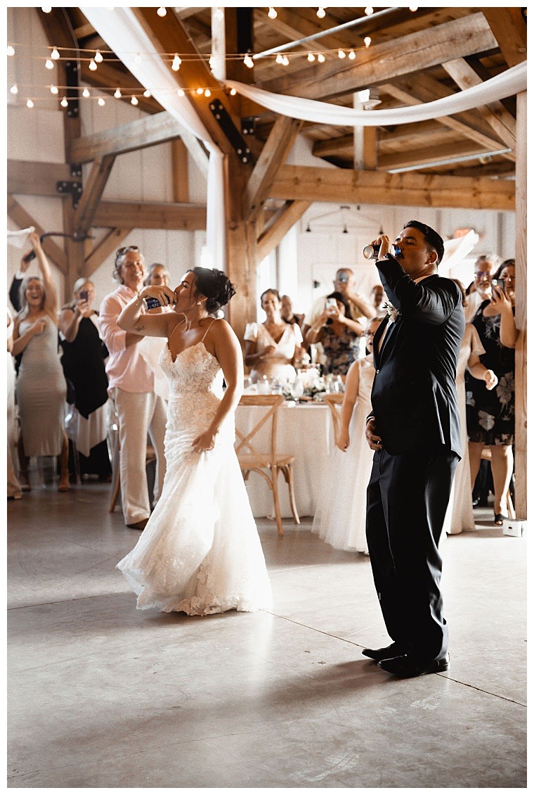 The bride and groom enter the Breckenridge Barn reception and kick off their first dance with a drink