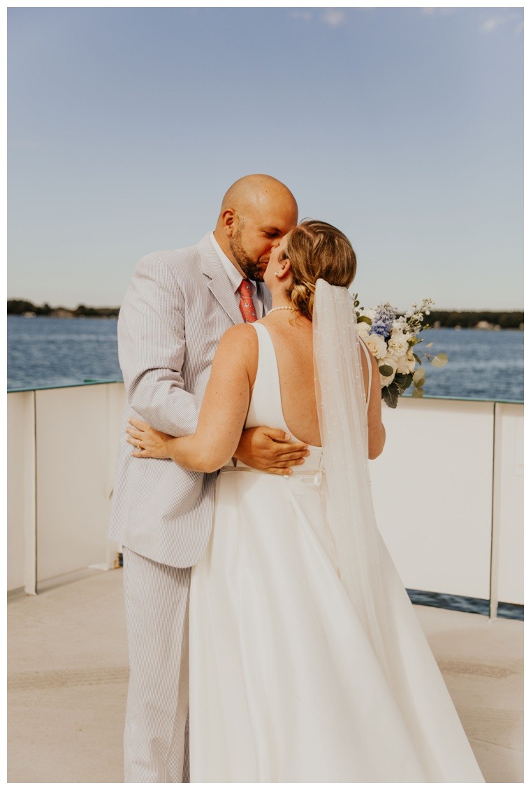 The bride and groom share a kiss on the Oxford Bellevue Ferry during their private first look