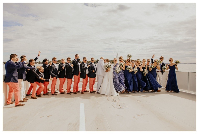The bridal party cheers as the bride and groom share a kiss on the Oxford Bellevue Ferry