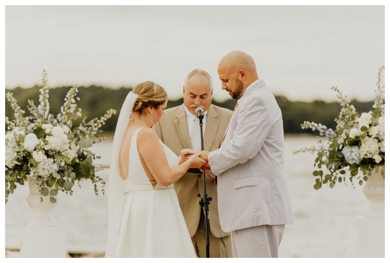 The bride and groom exchange wedding rings during their waterfront ceremony on the Tred Avon River