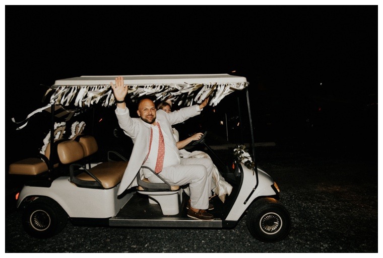 The bride and groom make their getaway in a decked out bridal golf cart
