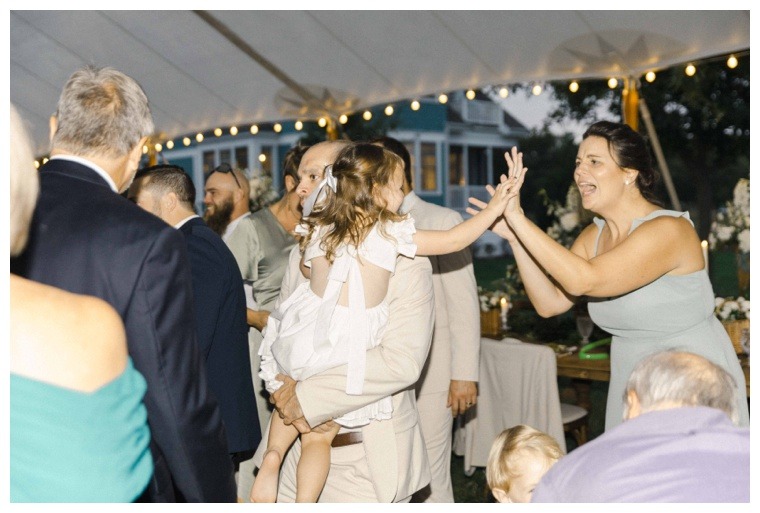 Flower girl dances with guests on the lawn at the Inn at Haven Harbour