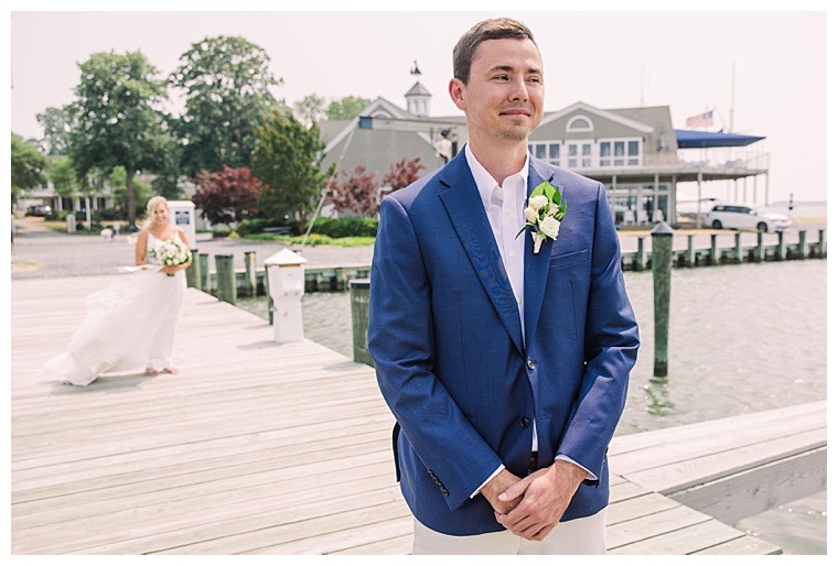 The groom waits patiently for his bride on their wedding as they meet on the dock at the Tred Avon yacht Club for a first look with Laura's Focus Photography