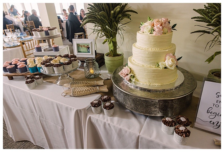 A dessert bar with a 3 tiered wedding cake and cupcakes by Peachblossom Events