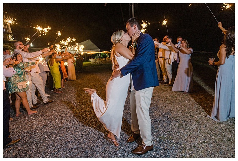 The bride and groom exit their Tred Avon Yacht Club through a sparkler tunnel of friends and family