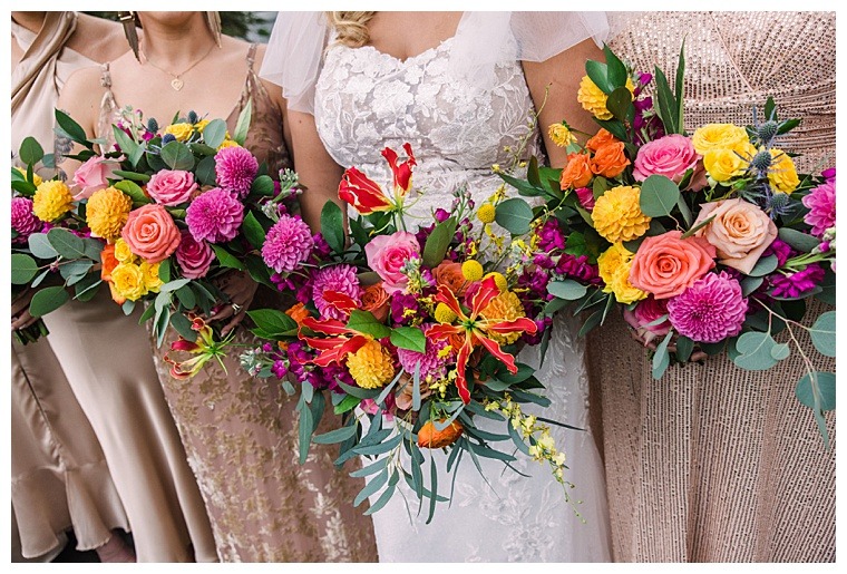 Bright and bold florals with pops of pink, yellow, and orange stand out beautifully against the simple nude bridesmaids dresses