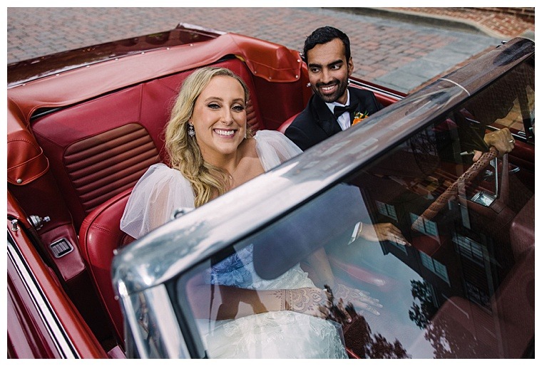 My Eastern Shore Wedding | The bride and groom sit in a classic getaway car with stunning red leather interior