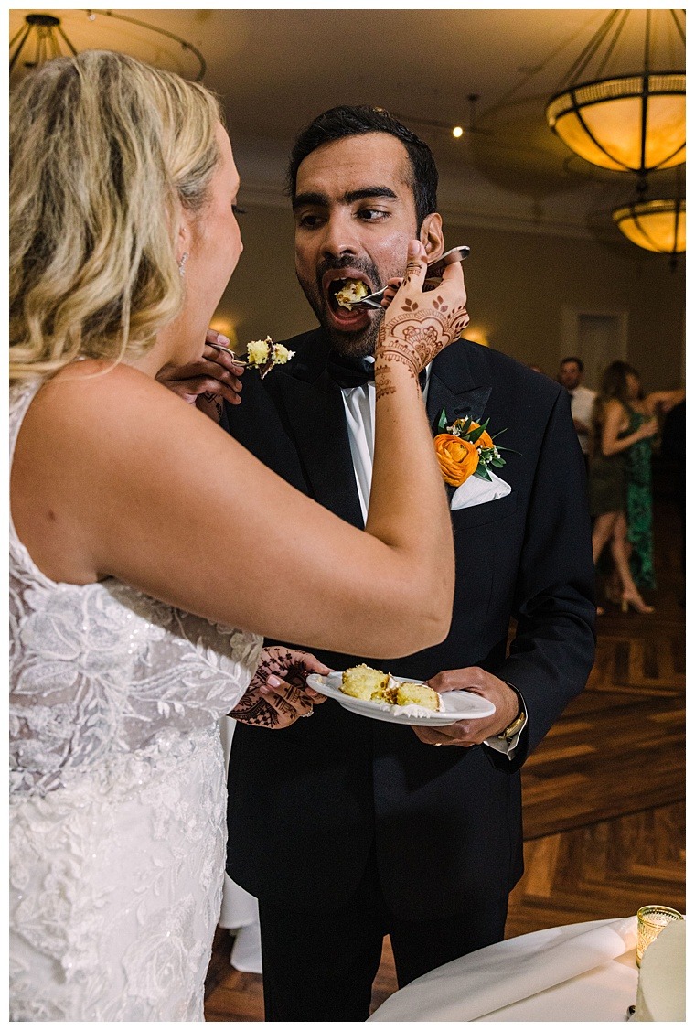 The bride and groom share the ceremonial first piece of wedding cake by Graul's Market Bakery