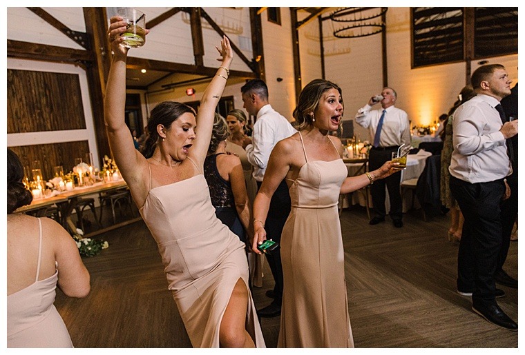 The bridal party tears up the dance floor with drinks in hand in celebration of the newlyweds