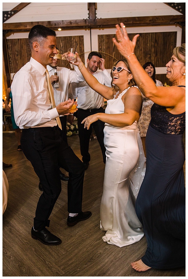 The bride is all smiles on the dance floor in a stunning chic satin dress