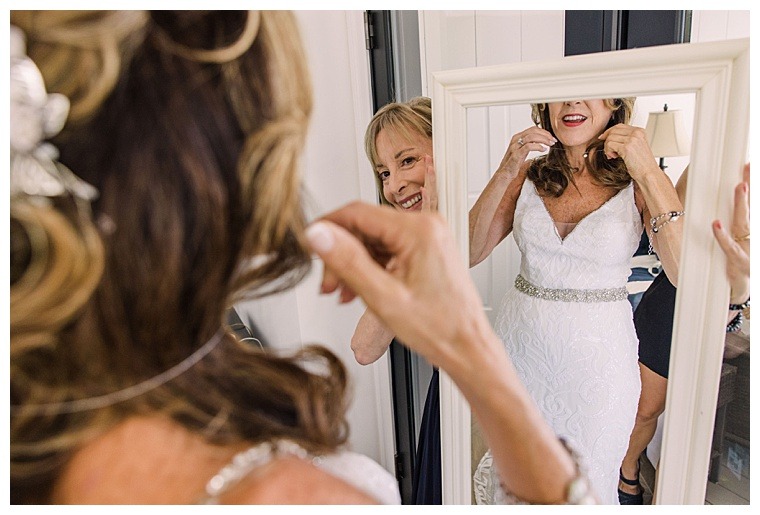 With the help of family and close friends, the bride gets ready for her big day, dressed in a stunning white lace gown and statement jewelry
