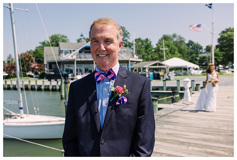 Standing on the dock at The Tred Avon Yacht Club, the groom patiently awaits his bride as they meet for their waterfront first look.