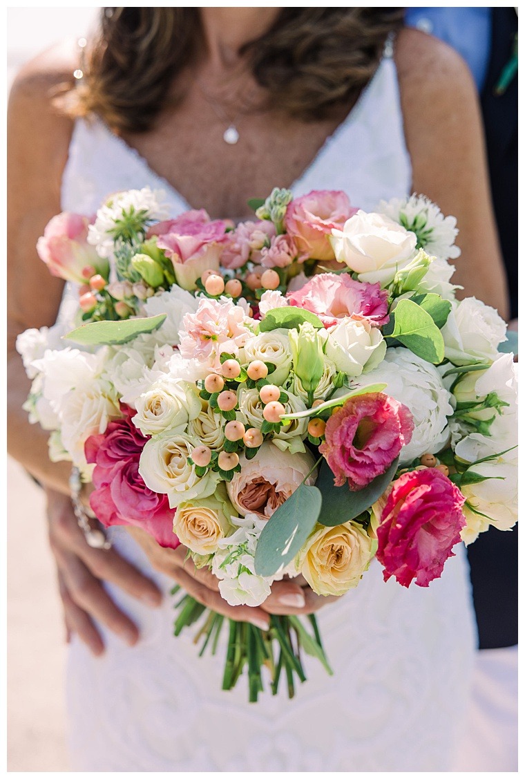 Close-up of the bride's stunning wedding gown and bouquet of fresh flowers.