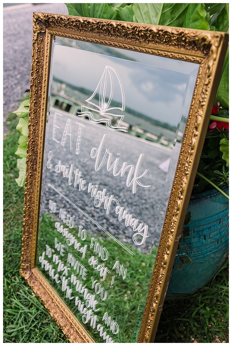 A custom cocktail hour sign is painted on a golden framed mirror for Barbie and Steve's Oxford MD wedding day